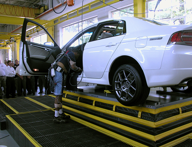 Man working on a white car that is lifted up by SPC Industrial products.